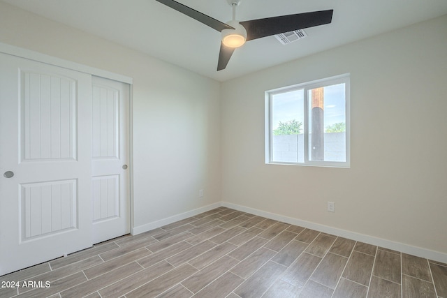 unfurnished bedroom featuring ceiling fan, a closet, and light wood-type flooring