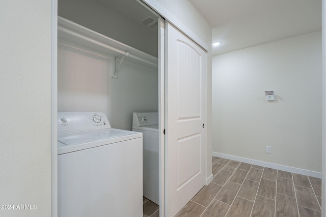 clothes washing area featuring hardwood / wood-style flooring and independent washer and dryer