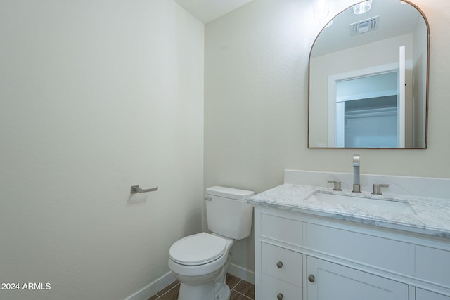 bathroom with tile patterned flooring, vanity, and toilet