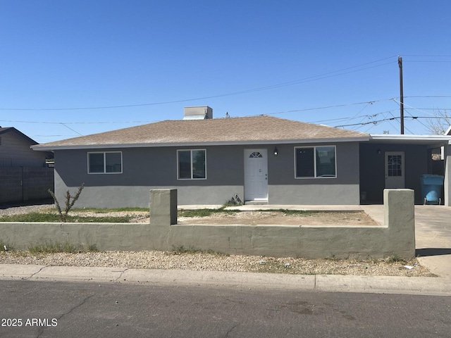 single story home featuring stucco siding, a shingled roof, and fence