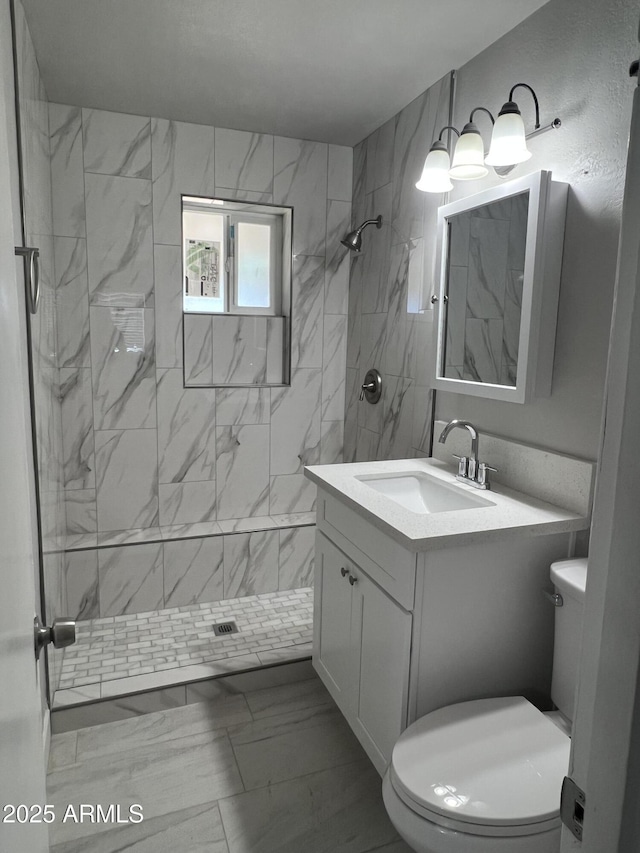 full bath with vanity, toilet, a stall shower, and marble finish floor