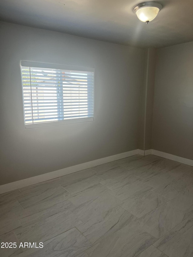 spare room with baseboards