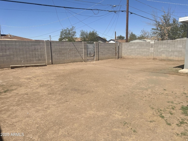 view of yard with a fenced backyard and a gate