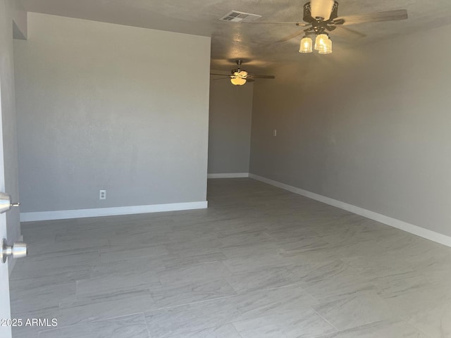 unfurnished room with visible vents, marble finish floor, a ceiling fan, and baseboards