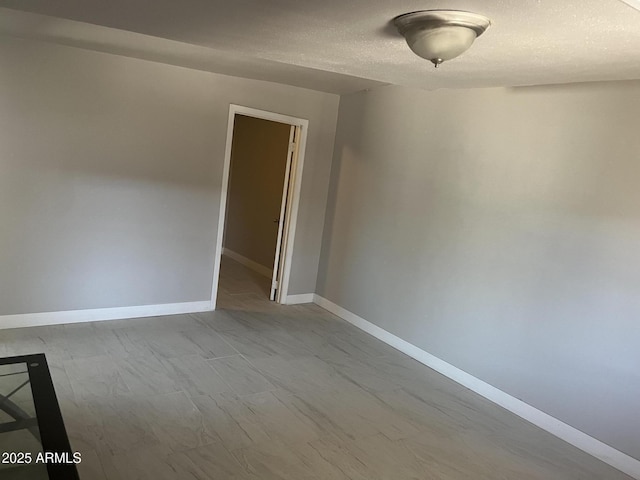 unfurnished room featuring baseboards and a textured ceiling