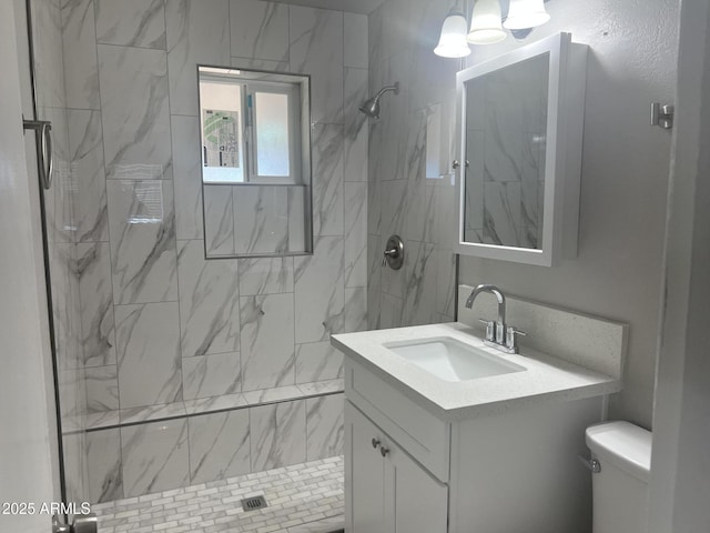 bathroom with vanity, a shower stall, and toilet