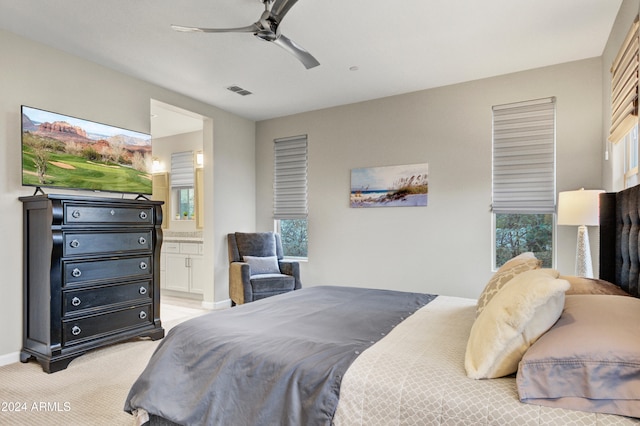 carpeted bedroom featuring ceiling fan and ensuite bathroom