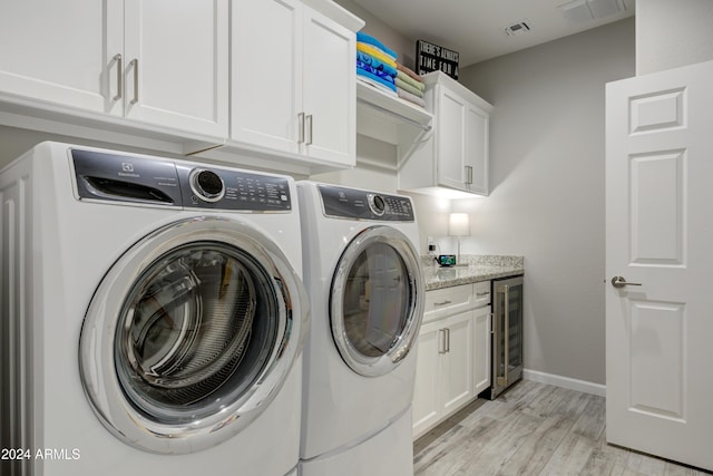 laundry area with separate washer and dryer, light hardwood / wood-style flooring, cabinets, and wine cooler