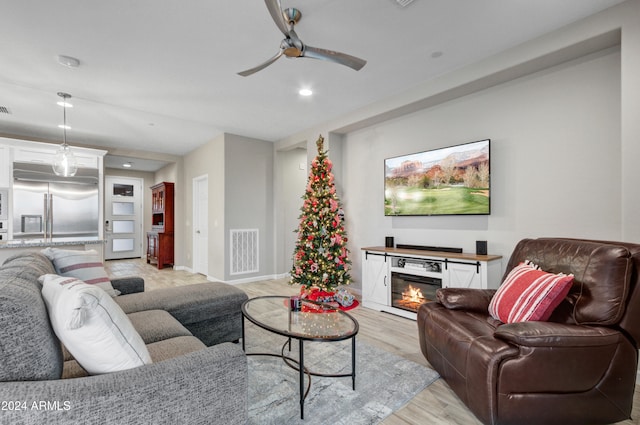 living room featuring ceiling fan and light wood-type flooring