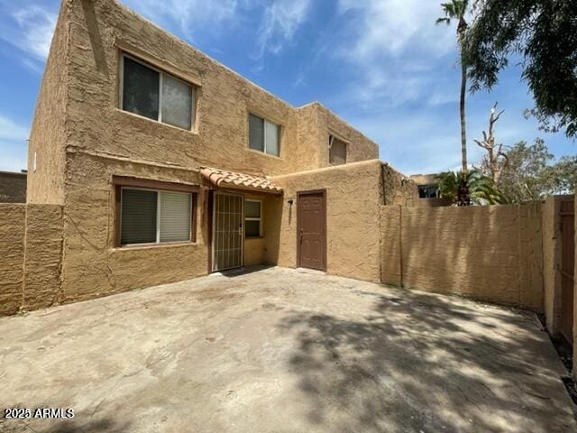 view of front of house featuring fence and a patio area