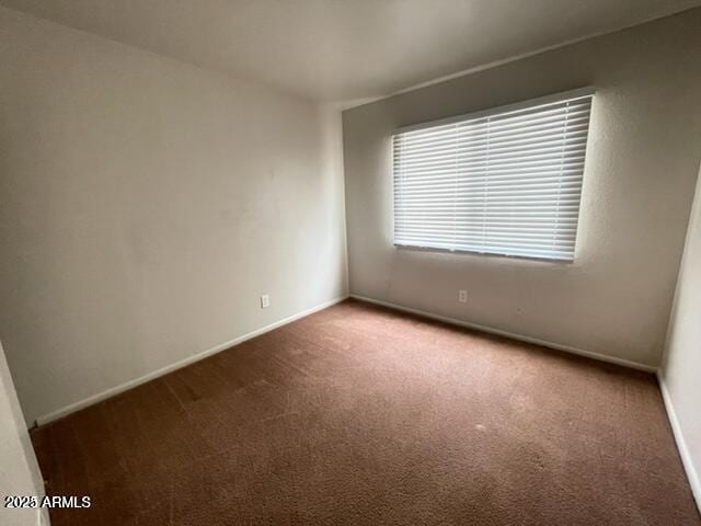 carpeted spare room with baseboards