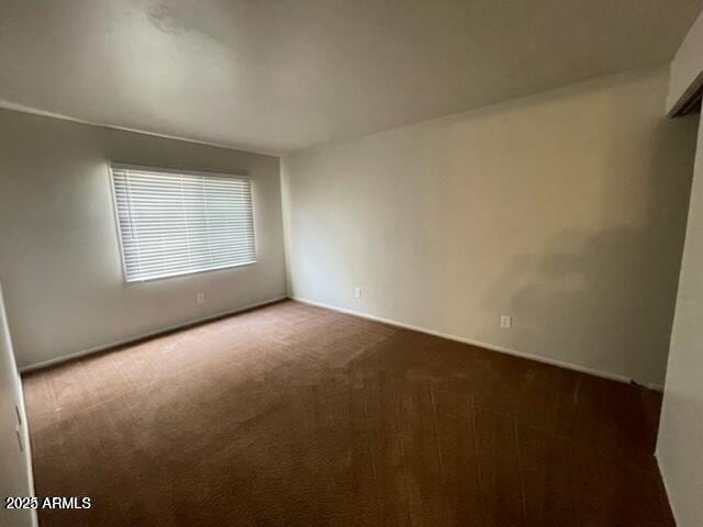 empty room with baseboards and carpet flooring