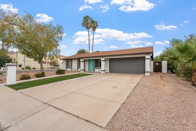 ranch-style house with concrete driveway, an attached garage, and stucco siding