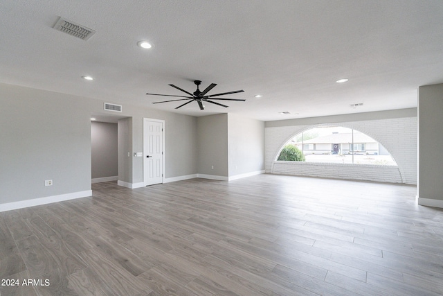 empty room featuring ceiling fan, hardwood / wood-style flooring, and a textured ceiling