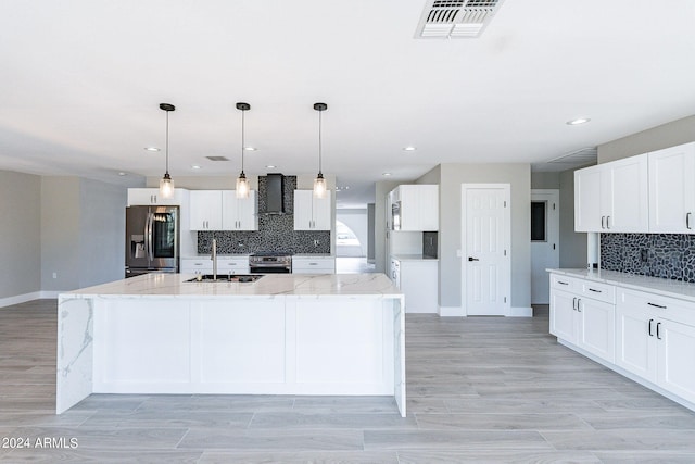 kitchen featuring stainless steel appliances, light hardwood / wood-style floors, white cabinetry, sink, and a large island