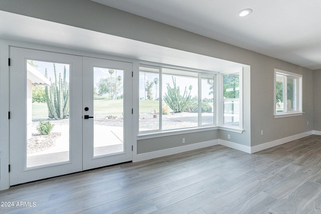 doorway to outside with a wealth of natural light, french doors, and light hardwood / wood-style floors