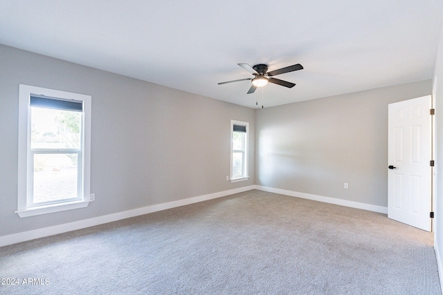 spare room featuring plenty of natural light, ceiling fan, and carpet flooring