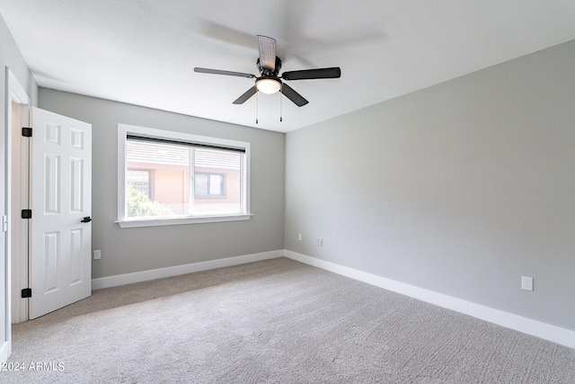 spare room with light colored carpet and ceiling fan