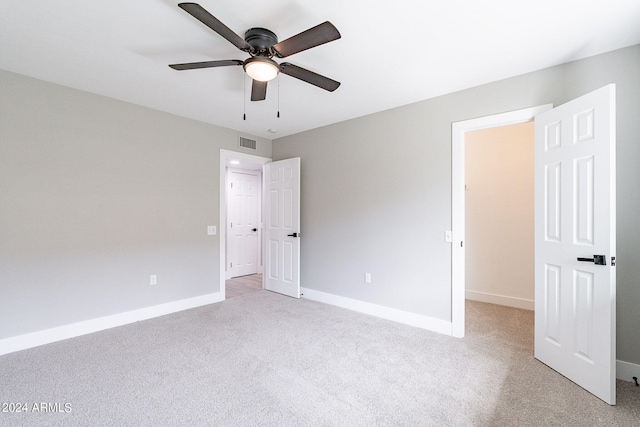 unfurnished bedroom with ceiling fan and light colored carpet