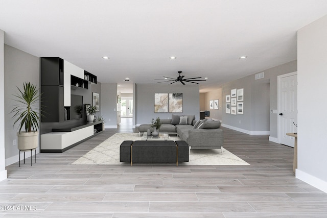 living room featuring light wood-type flooring and ceiling fan