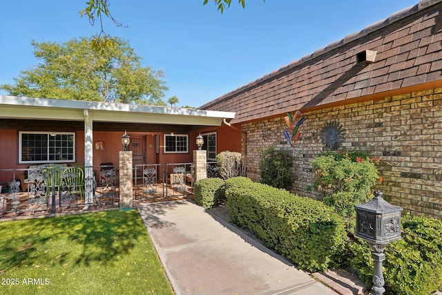 view of exterior entry featuring covered porch