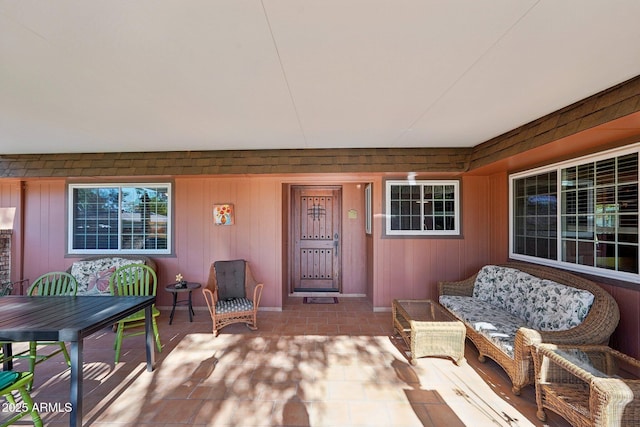 view of exterior entry featuring an outdoor living space and a patio