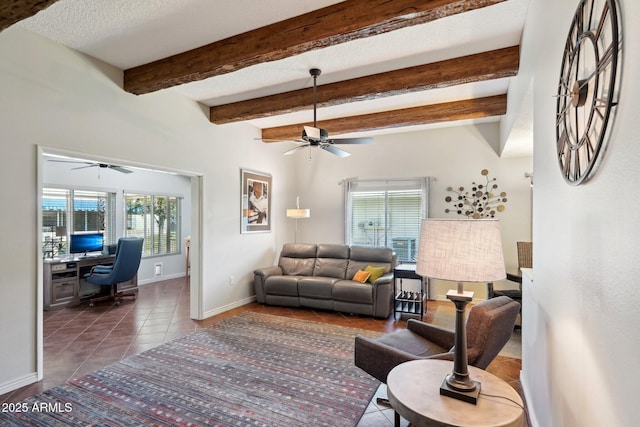 living room featuring ceiling fan, a textured ceiling, beamed ceiling, and dark tile patterned floors