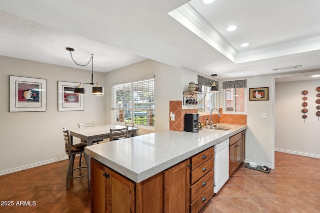 kitchen featuring white dishwasher, pendant lighting, tasteful backsplash, and a healthy amount of sunlight