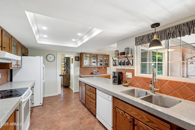 kitchen featuring sink, hanging light fixtures, a tray ceiling, crown molding, and white appliances