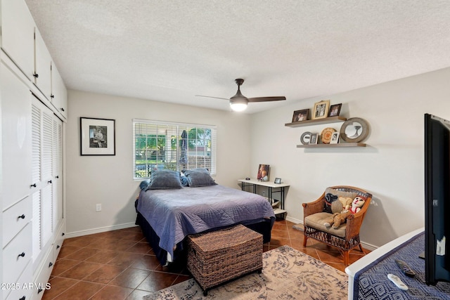 tiled bedroom featuring ceiling fan, a closet, and a textured ceiling