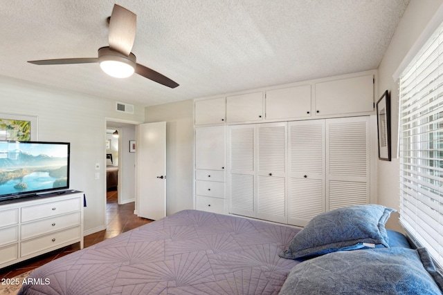 bedroom featuring ceiling fan, a textured ceiling, and a closet