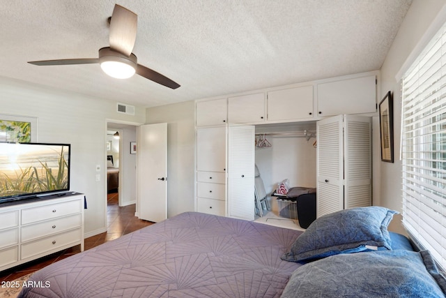 bedroom with ceiling fan, a closet, and a textured ceiling