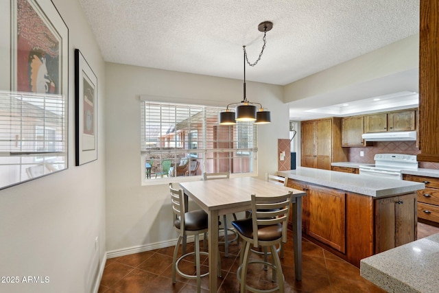 dining area with dark tile patterned flooring and a textured ceiling