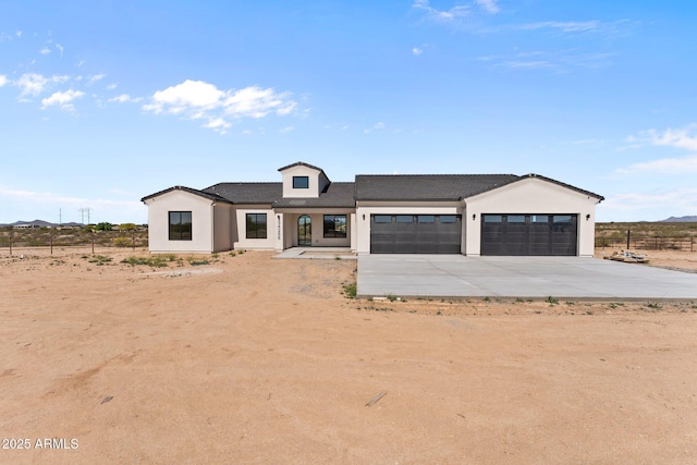 34256 S State Route 89th Hwy, Wickenburg, AZ 85390 - modern farmhouse with concrete driveway, a garage, and stucco siding