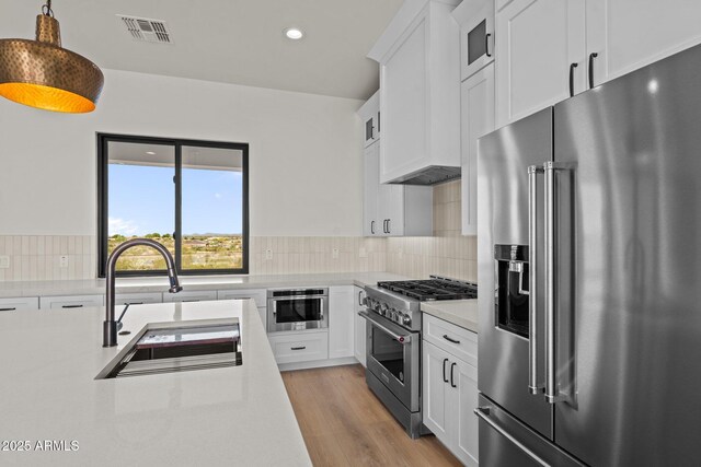 34256 S State Route 89th Hwy, Wickenburg, AZ 85390 - kitchen with premium appliances, a sink, light countertops, white cabinets, and recessed lighting