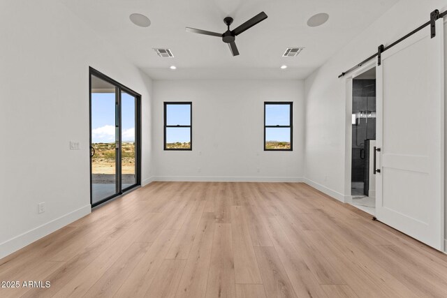 34256 S State Route 89th Hwy, Wickenburg, AZ 85390 - spare room featuring a barn door, light wood finished floors, healthy amount of natural light, a ceiling fan, and recessed lighting