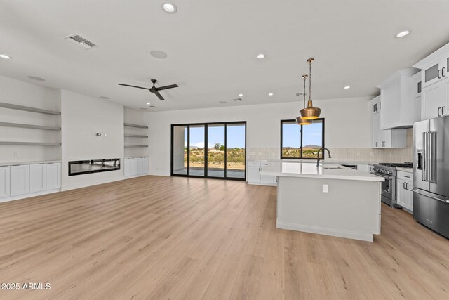 34256 S State Route 89th Hwy, Wickenburg, AZ 85390 - kitchen with high end appliances, recessed lighting, light countertops, a center island with sink, and a ceiling fan