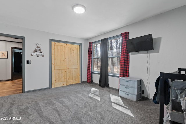 carpeted bedroom with fridge and baseboards