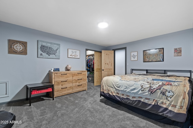 bedroom with a walk in closet, a closet, and carpet flooring