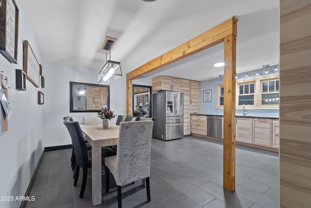 dining area featuring baseboards, beam ceiling, and track lighting