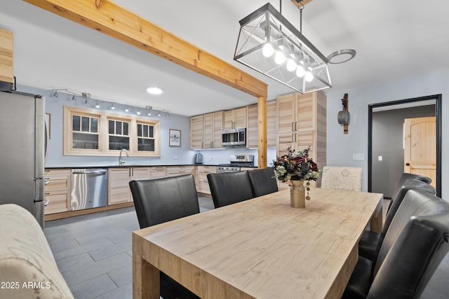 dining space featuring beamed ceiling and wood finished floors