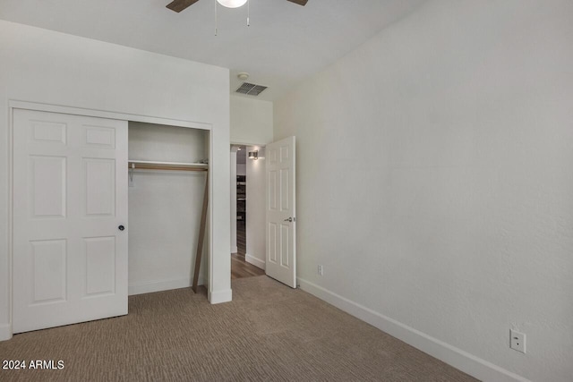 unfurnished bedroom featuring light colored carpet, a closet, and ceiling fan