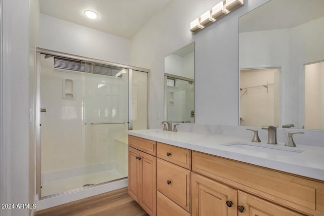 bathroom with an enclosed shower, hardwood / wood-style floors, and dual bowl vanity