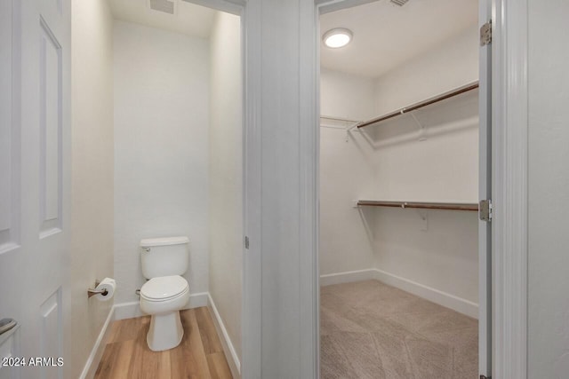 bathroom featuring wood-type flooring and toilet