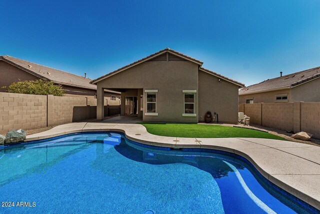 view of pool with a patio area and a yard