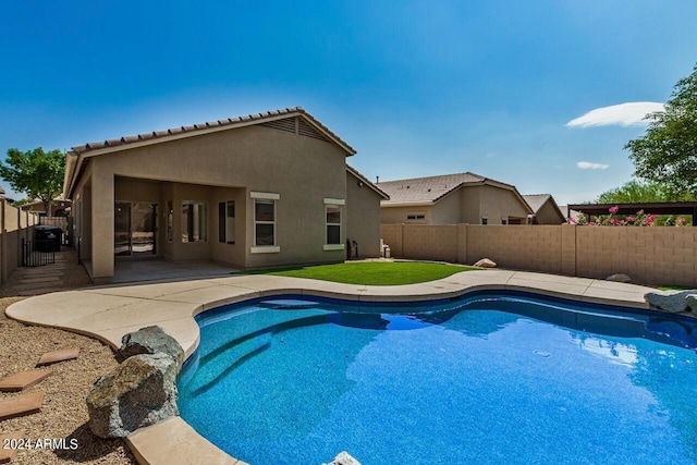 view of swimming pool with a patio and a lawn