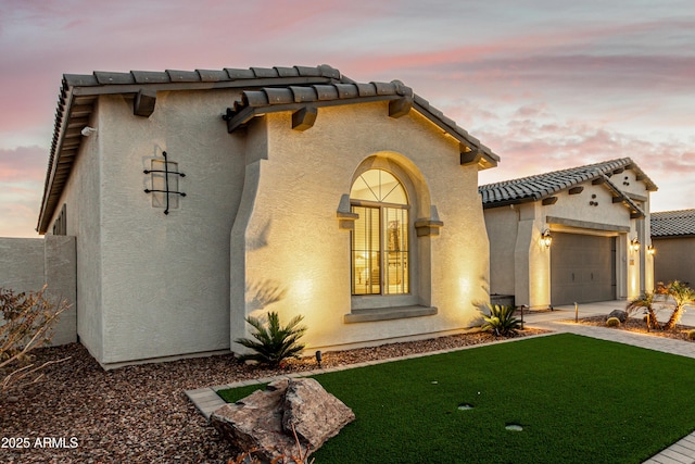 mediterranean / spanish house featuring a garage and a lawn