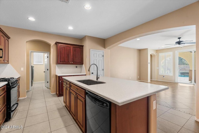 kitchen featuring ceiling fan, sink, a center island with sink, light tile patterned floors, and black appliances