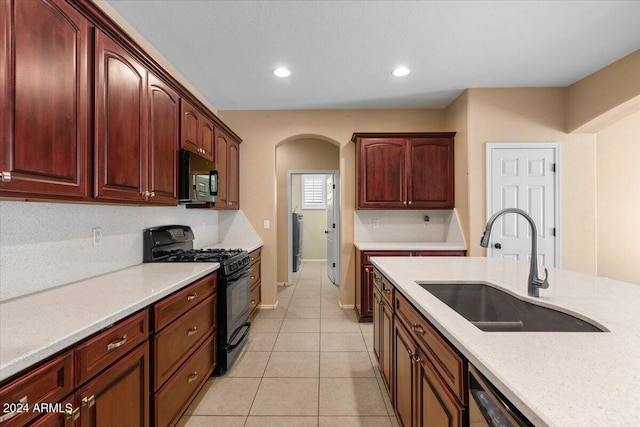 kitchen with sink, black range with gas cooktop, and light tile patterned floors