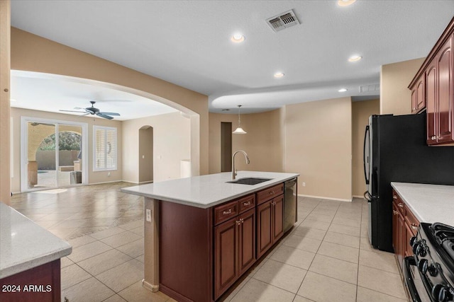 kitchen featuring dishwasher, a center island with sink, black range with gas stovetop, sink, and ceiling fan